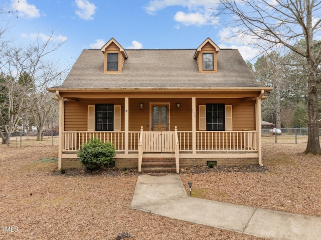 view of front of house featuring a shingled roof, fence, and a porch