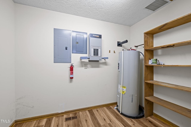 utilities featuring visible vents, electric water heater, and electric panel