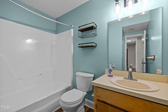 bathroom with washtub / shower combination, vanity, and toilet