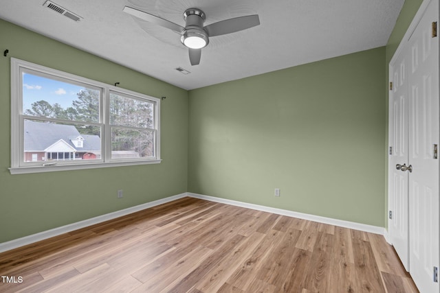 unfurnished bedroom featuring a closet, light wood-type flooring, visible vents, and baseboards