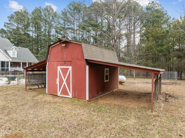 view of barn with a yard and fence