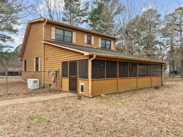 back of property with a sunroom and fence