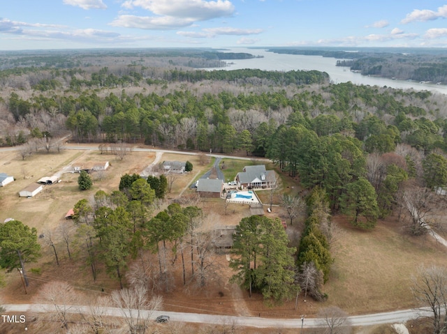 drone / aerial view with a water view and a forest view