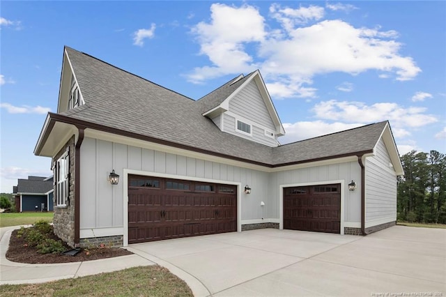 view of side of home featuring concrete driveway, roof with shingles, and an attached garage