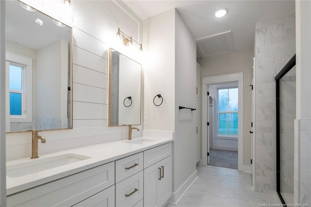 bathroom with a shower, double vanity, marble finish floor, and a sink