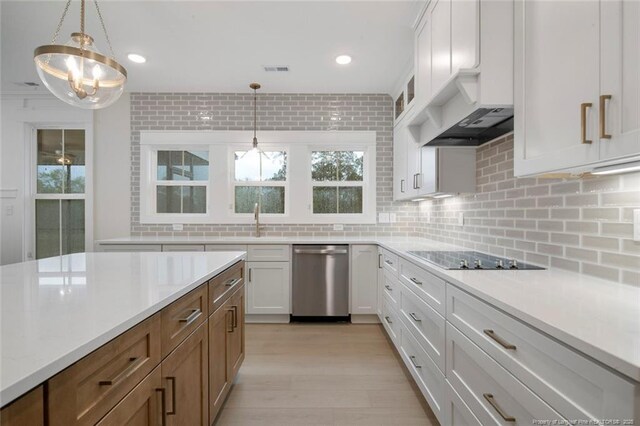 kitchen featuring tasteful backsplash, hanging light fixtures, black electric cooktop, stainless steel dishwasher, and ventilation hood