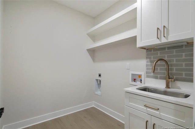 laundry room featuring baseboards, washer hookup, a sink, cabinet space, and electric dryer hookup