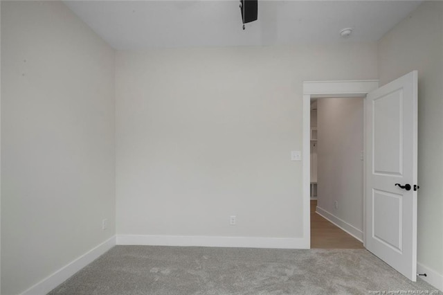 carpeted empty room featuring baseboards
