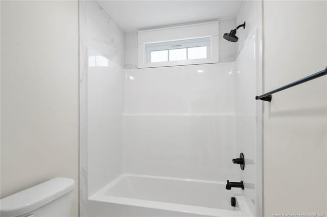 bathroom with bathing tub / shower combination and toilet