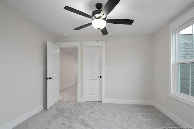 unfurnished bedroom featuring ceiling fan, light colored carpet, and baseboards