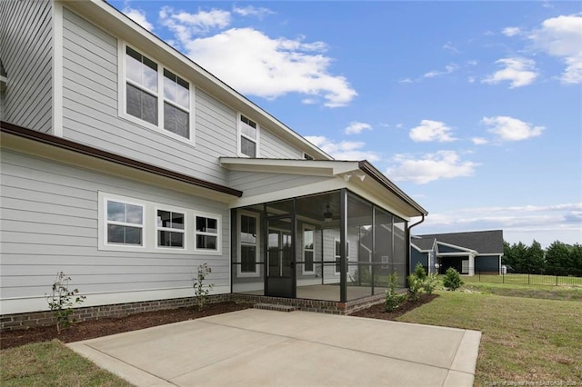 back of property with a patio area, a yard, and a sunroom