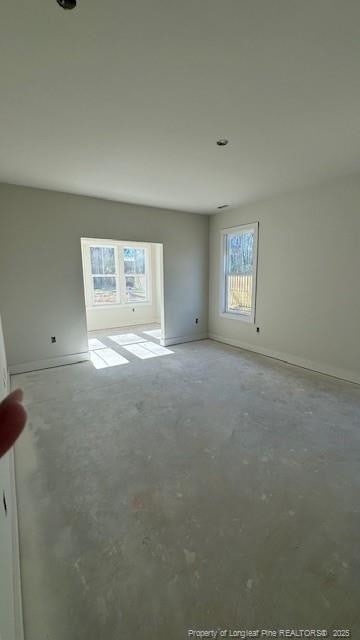 spare room with concrete floors and baseboards