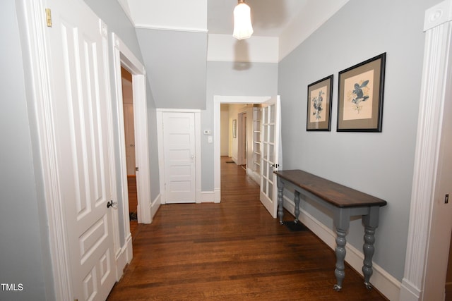 corridor featuring baseboards and wood finished floors