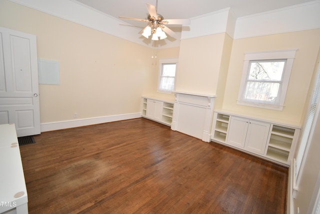 spare room with dark wood-type flooring, crown molding, baseboards, and a ceiling fan