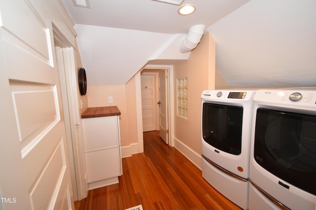 clothes washing area featuring washer and dryer, dark wood finished floors, and baseboards