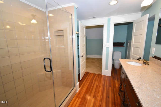 full bathroom featuring visible vents, a shower stall, vanity, wood finished floors, and baseboards