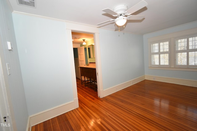 unfurnished room with visible vents, baseboards, and wood finished floors