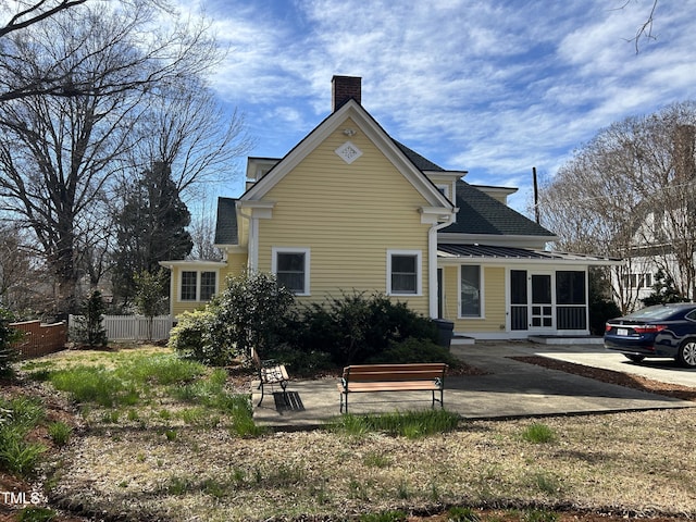 rear view of house with fence and a chimney