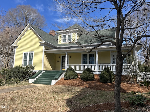 view of front of house with a porch and roof with shingles