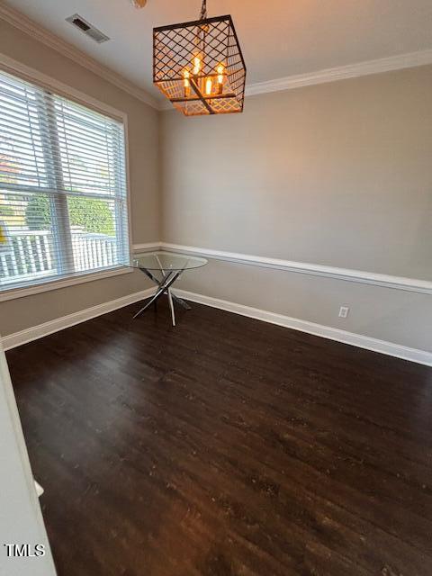 spare room with baseboards, visible vents, dark wood-style flooring, and crown molding