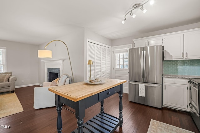 kitchen with dark wood-style floors, stainless steel appliances, and white cabinetry