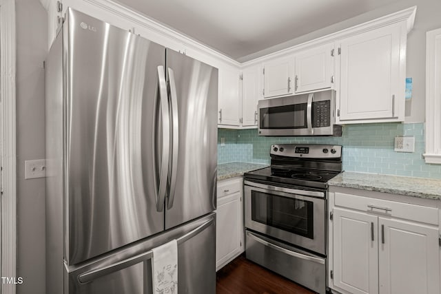 kitchen featuring light stone countertops, white cabinetry, appliances with stainless steel finishes, and backsplash