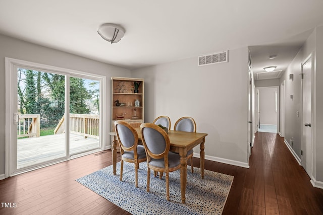 dining area featuring baseboards, dark wood-style flooring, visible vents, and attic access