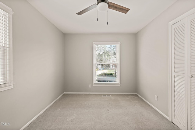 unfurnished bedroom featuring visible vents, baseboards, ceiling fan, carpet, and a closet