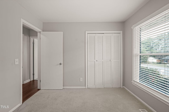 unfurnished bedroom featuring a closet, carpet, and baseboards