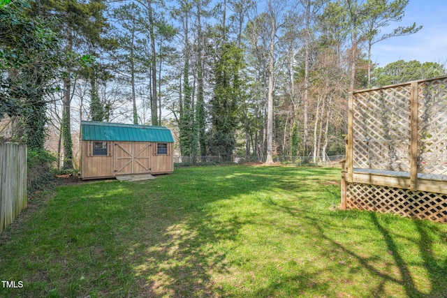 view of yard with a deck, a shed, an outdoor structure, and a fenced backyard