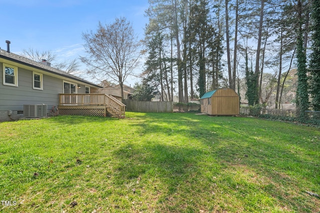 view of yard with an outbuilding, a storage unit, a deck, cooling unit, and a fenced backyard