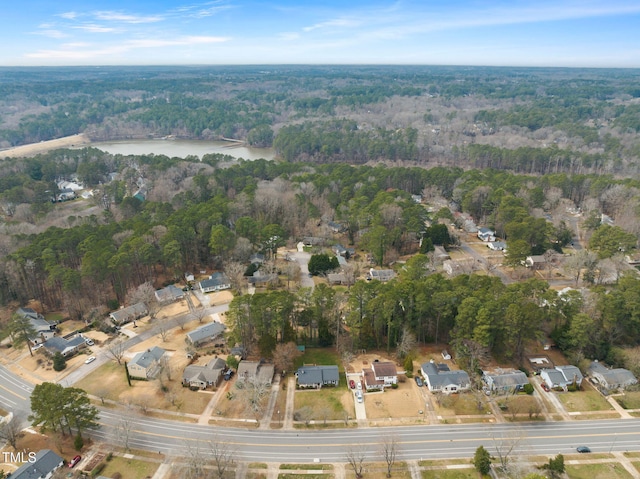 birds eye view of property featuring a water view and a wooded view