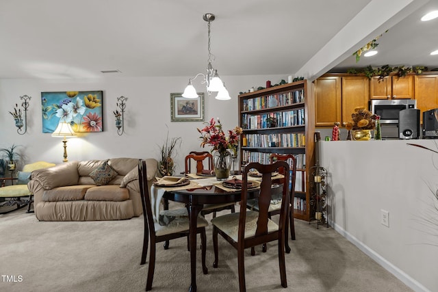 dining room featuring a chandelier, light carpet, and visible vents