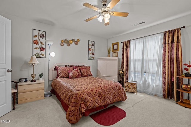 bedroom featuring light colored carpet, ceiling fan, and visible vents