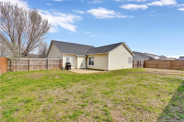 back of property featuring a yard, a patio area, and a fenced backyard