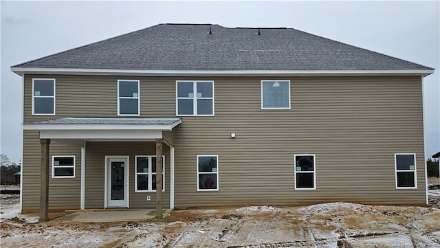 back of house featuring a shingled roof and a patio area