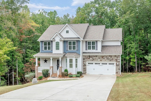 view of front of house featuring concrete driveway, stone siding, roof with shingles, covered porch, and a front yard