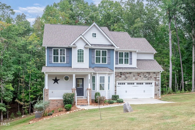 view of front of property with a front lawn, stone siding, roof with shingles, and covered porch