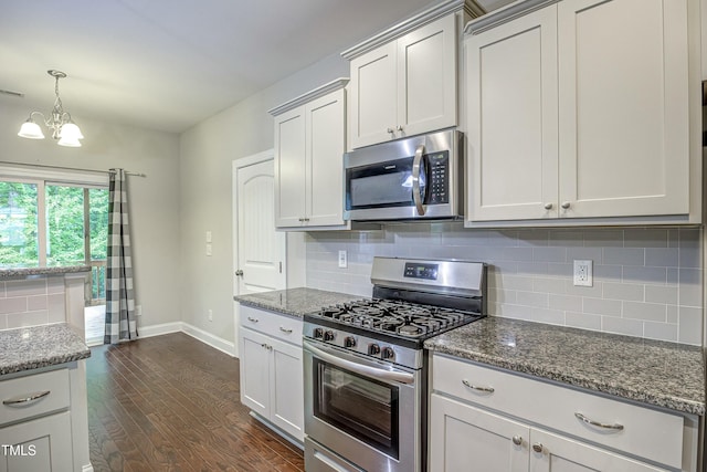 kitchen featuring stainless steel appliances, dark wood-style flooring, dark stone countertops, and decorative backsplash