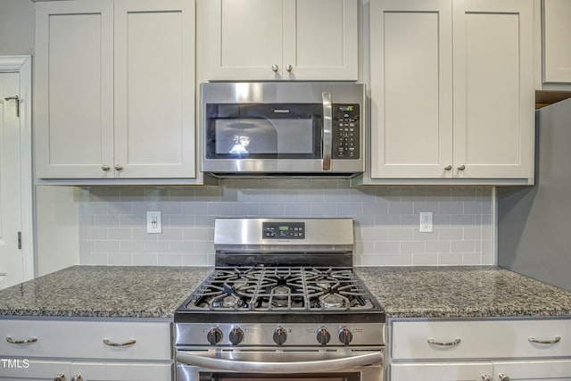 kitchen with dark stone counters, appliances with stainless steel finishes, and decorative backsplash