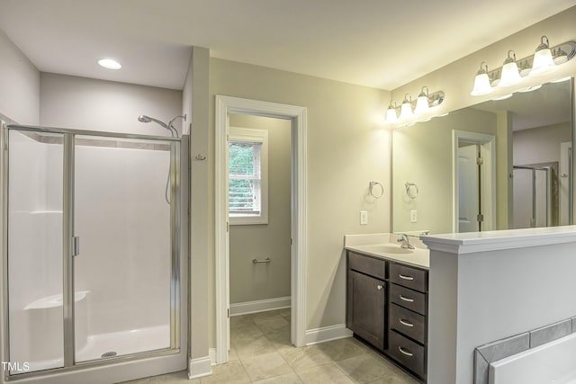 bathroom featuring tile patterned flooring, a shower stall, baseboards, and vanity