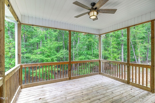 wooden deck featuring a wooded view and a ceiling fan