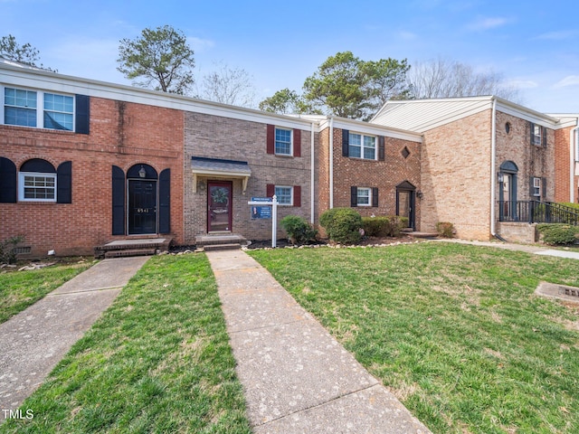 townhome / multi-family property with a front lawn and brick siding