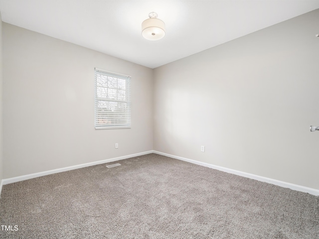 spare room featuring carpet and baseboards