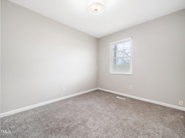 carpeted empty room featuring visible vents and baseboards