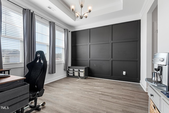 office featuring ornamental molding, a tray ceiling, visible vents, and a decorative wall