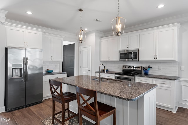 kitchen with dark wood-style floors, stainless steel appliances, visible vents, white cabinets, and a sink