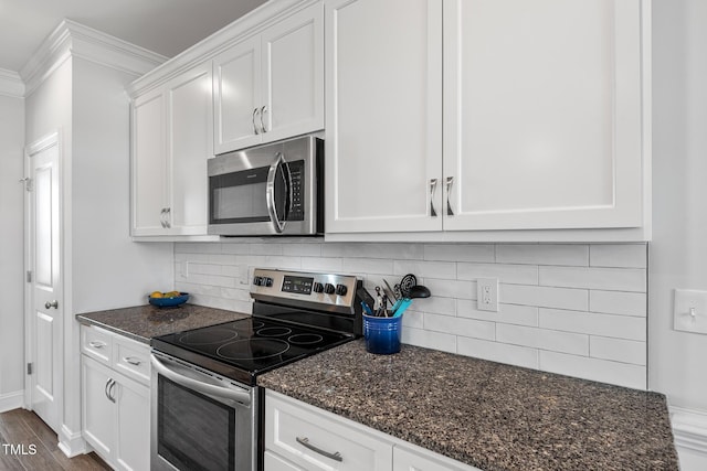 kitchen featuring stainless steel appliances, white cabinets, ornamental molding, and backsplash