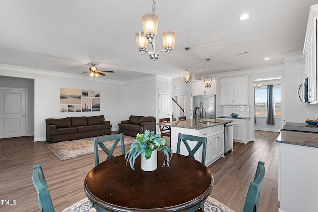 dining room with dark wood-style floors, recessed lighting, ornamental molding, and ceiling fan with notable chandelier