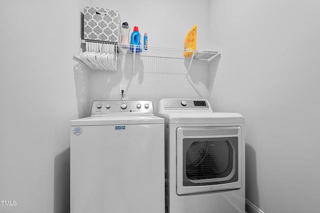 laundry room with laundry area, washer and clothes dryer, and baseboards